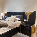 Black Leather Upholstered Bed with Textured Gold Accents, Patterned Quilted Detailing & Brass Hardware Feet